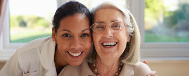 Nurse and older woman smiling together